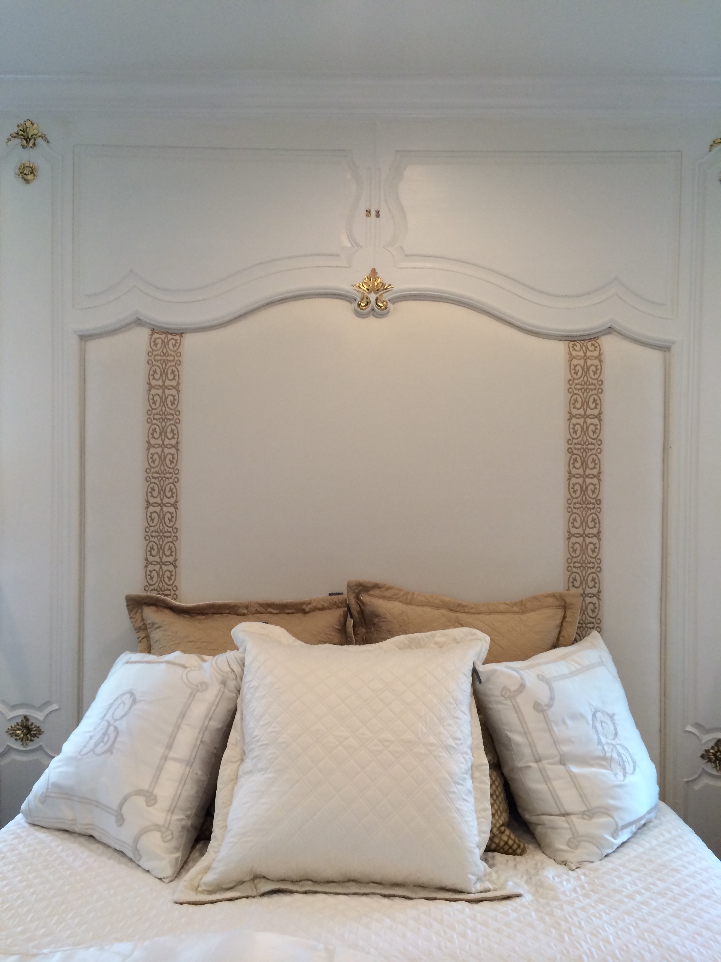 Custom white cushioned head board built into wall above bed in master bedroom